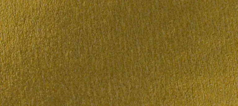 Close-up texture of a mustard yellow fabric or suede surface.
